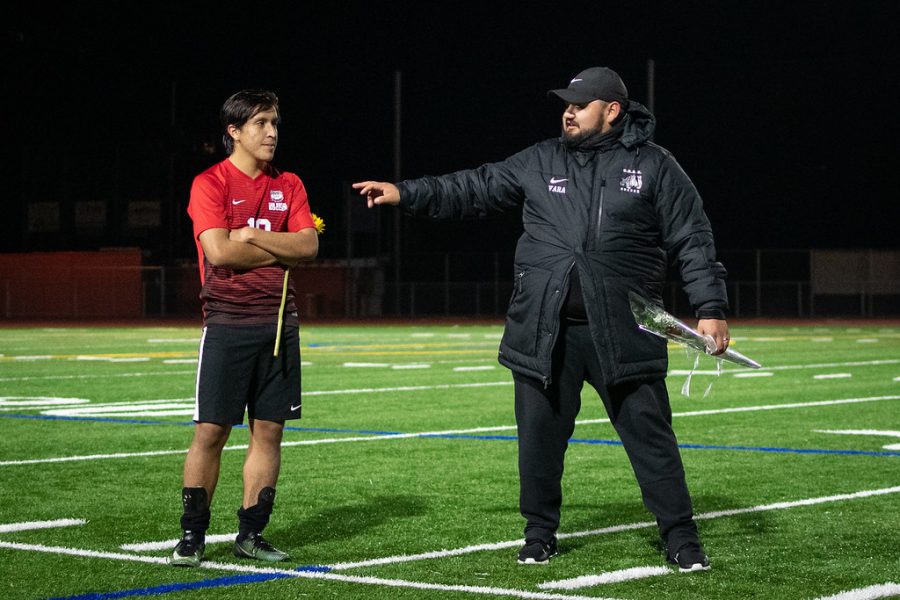 Chris Barrios, left, receives his senior night rose after his last MCAL game from coach Johnny Vara, right