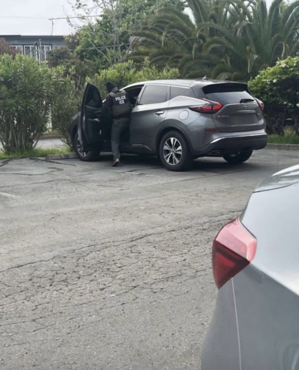 An ICE agent exiting a car.